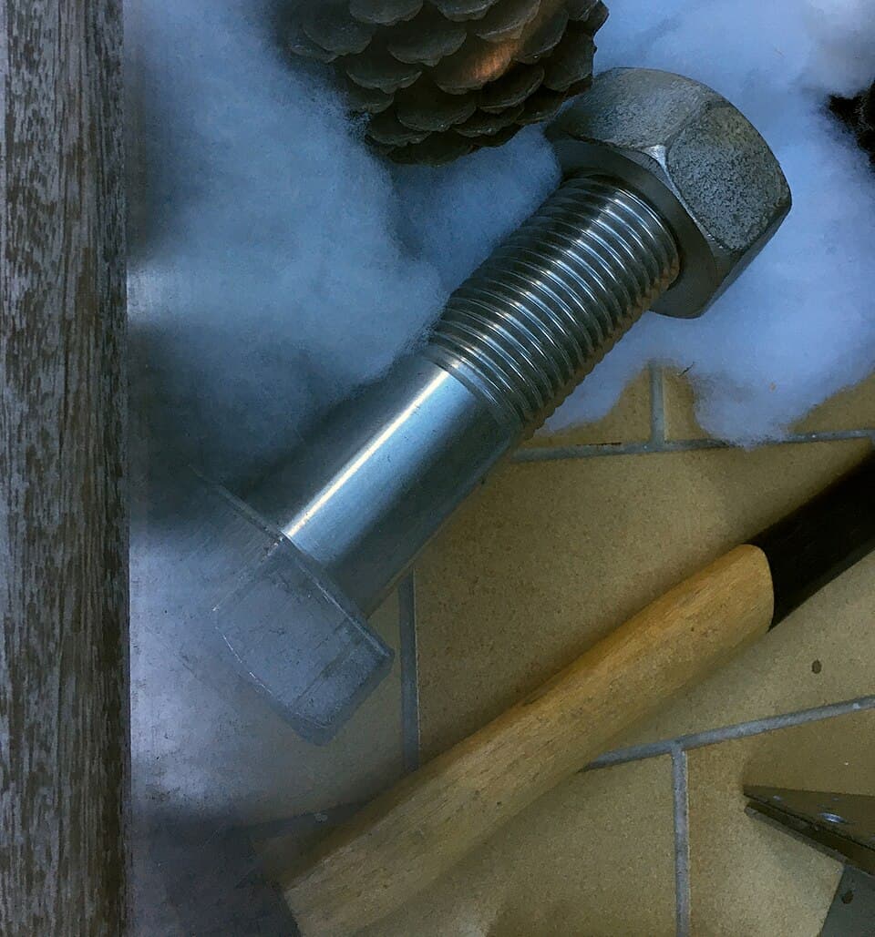 Large machine screw with diameter 45 mm and ca. 16 cm length, together with standard size hammer
