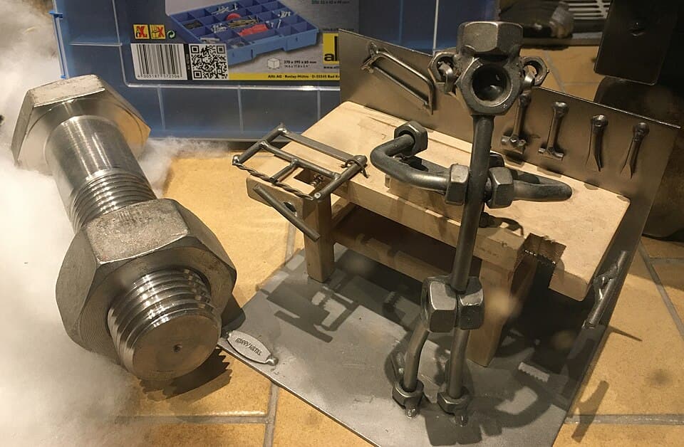 Shop window decoration with large bolt and nut, and model of mechanical workbench with "iron man"