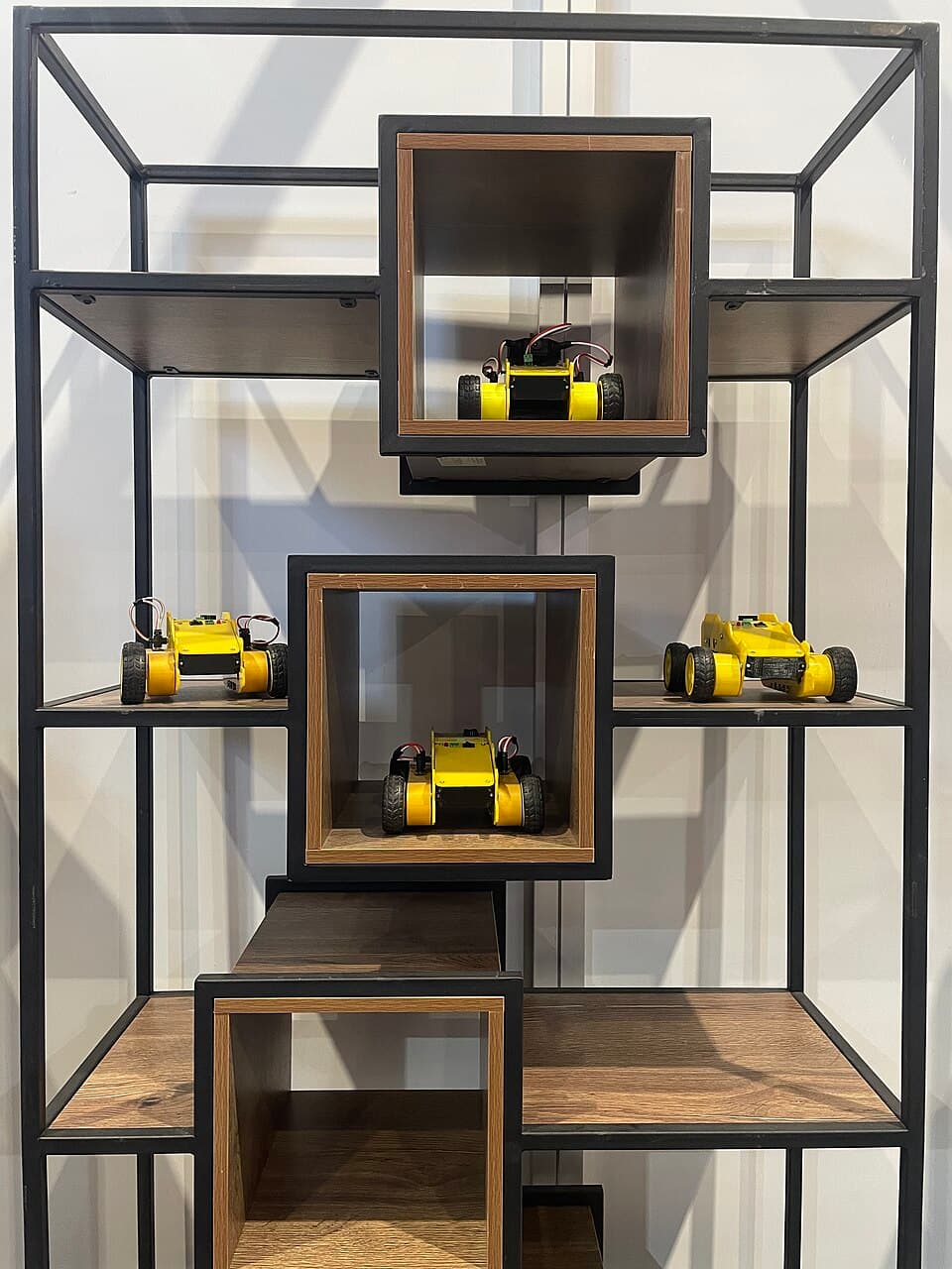 Small wheeled robot chassis displayed on shelves