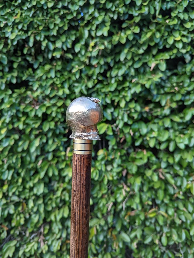 Brass casting of my excised arthritic femoral head and hip joint, with machined screw, affixed to custom cane.
