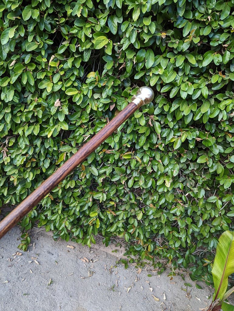 Brass casting of my excised arthritic femoral head and hip joint, with machined screw, affixed to custom cane.